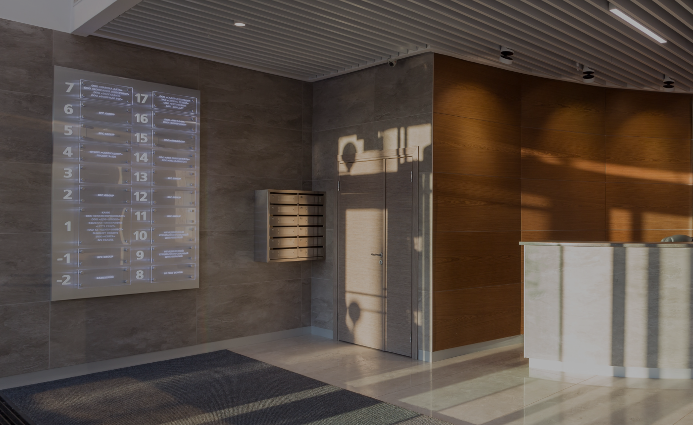 Der Eingangsbereich einer Praxis mit einer Holzwand und der Anmeldung bestehend aus einem Tisch mit Steinverkleidung.