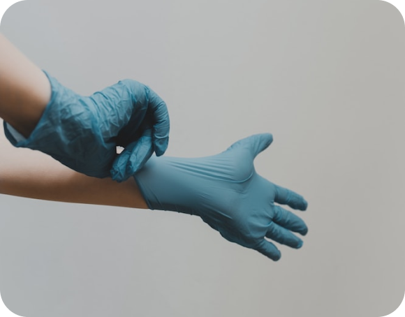 Ein Mensch zieht Arzthandschuhe an